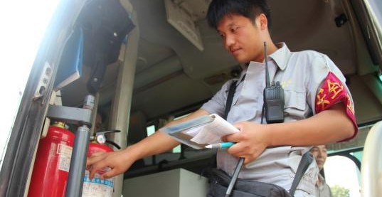 安檢員檢查長(zhǎng)途客車內(nèi)的滅火器圖
